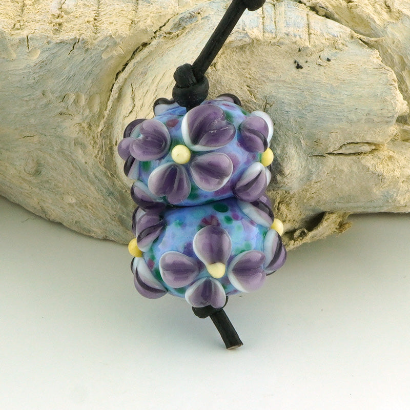 handmade glass beads with raised flowers in purple